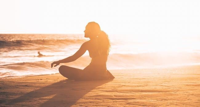 Eine Person sitzt am Strand