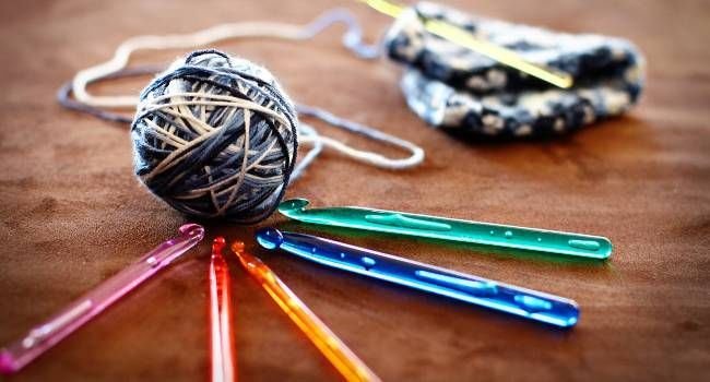 Mehrere Stricknadeln mit einem Ballen Strickgarn.