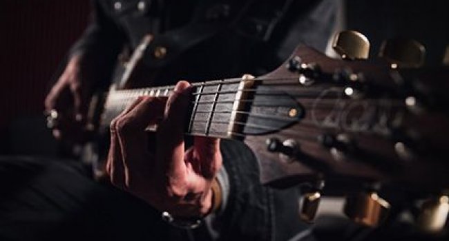 Ein sitzender Mann mit Gitarre