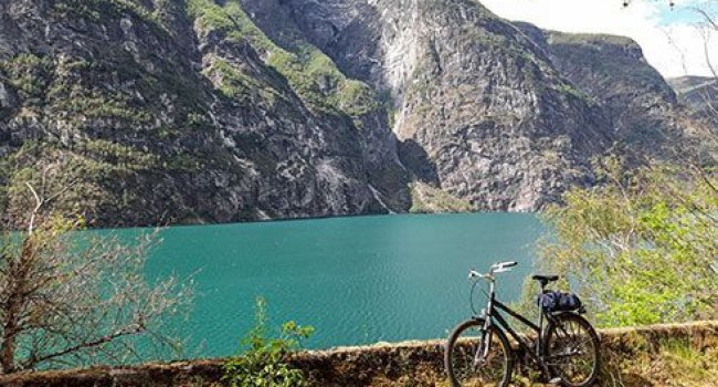 Ein Mountain Bike vor einem See und bergiger Landschaft