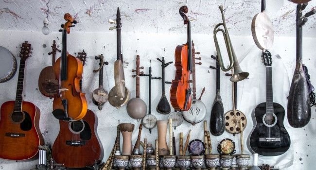 Gitarren an der Wand Eine Anzahl vieler verschiedener Gitarrentypen an der Wand aufgehängt.