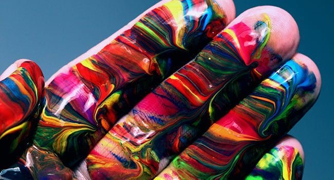 Hand einer Person mit vielen Farben bemalt