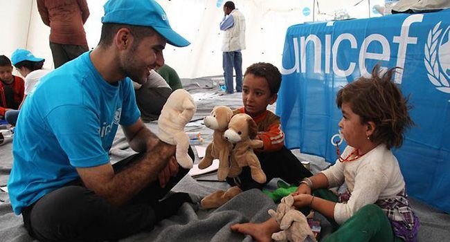 Ein UNICEF Mitarbeiter und Kinder