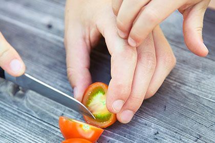 Photo by Markus Spiske on Unsplash Das Foto zeigt die Hände eines Erwachsenen, der eine Tomate schneidet und eine Kinderhand, die hilft.